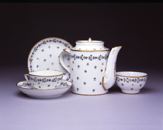 Pieces from a tea service with Chantilly sprig pattern: cup with handle, cup without handle (tea bowl), two saucers, and a teapot 